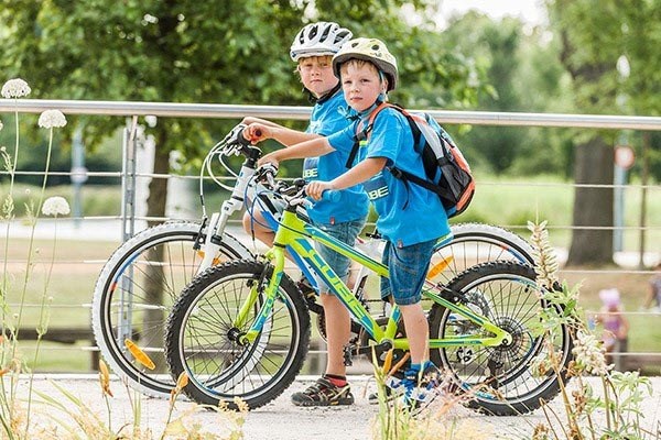 children cycling on footpath